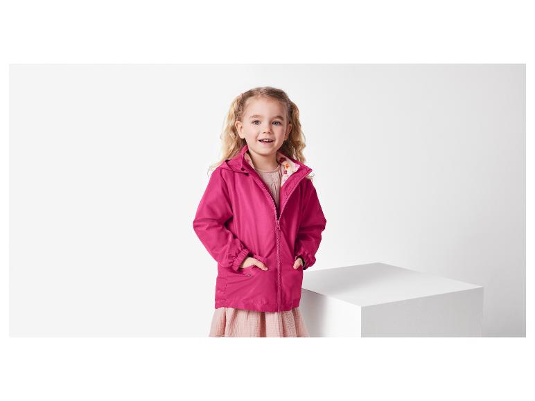 Une fillette portant une veste rose à capuche.