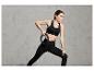 Une femme en soutien-gorge de sport noir et leggings s'entraîne avec un cercle d'exercice.