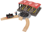 Ensemble de train en bois avec locomotive noire, conducteur et gare à trois voies.