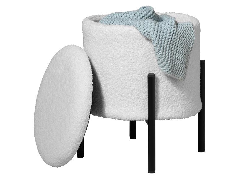 Pouf de rangement blanc texturé avec couvercle et pieds noirs, contenant une couverture tricotée bleue.