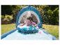 Enfante jouant sur un toboggan aquatique gonflable en forme de requin.