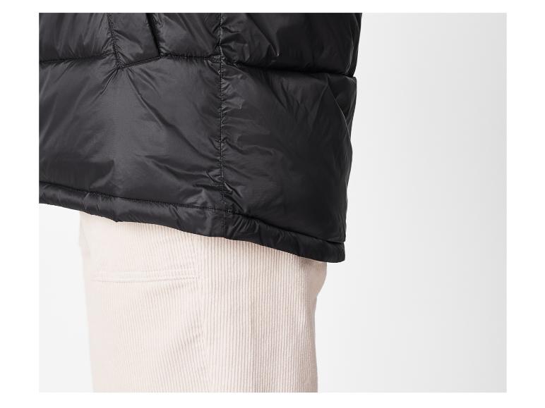 Veste noire rembourrée sur un pantalon en velours côtelé.