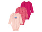 Trois bodies bébé à manches longues, un avec l'impression 'Lovely Day', un avec l'impression rose et un uni rose.