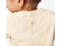 Haut beige en tissu léger pour bébé, boutons pression dans le dos.