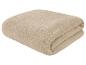Serviette en éponge beige pliée.