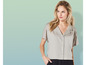 Une femme portant une chemise beige et un pantalon noir.