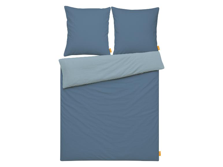 Parure de lit bleue avec deux oreillers et une couette en deux tons de bleu.