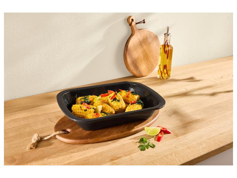 Épis de maïs rôtis au piment et citron vert dans un plat de cuisson noir sur un comptoir en bois.