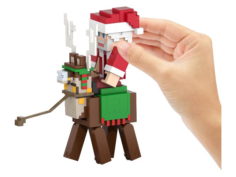 Une figurine Minecraft du Père Noël sur un renne, tenue par une main.