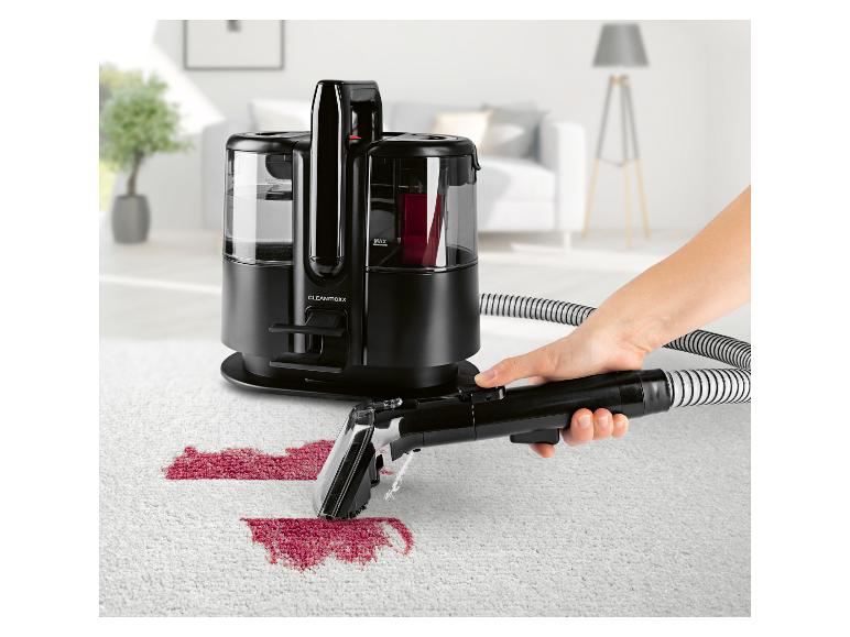 Nettoyeur de tapis en train d'enlever des taches rouges d'un tapis clair.