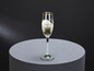 Une flûte de champagne avec un liseré doré sur une surface grise.
