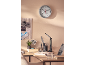 Horloge murale avec thermomètre et hygromètre, tableau d'affichage et lampe de bureau sur un bureau.