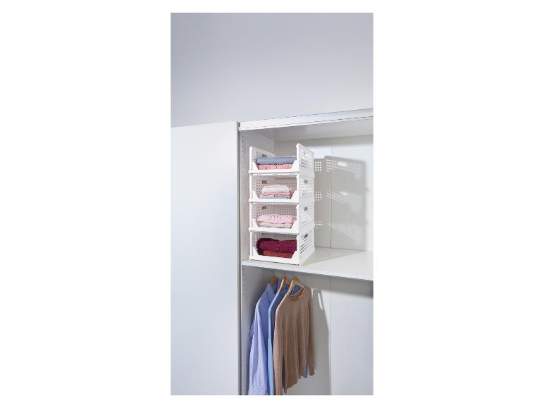 Étagère de rangement blanche à quatre niveaux remplie de vêtements pliés dans un placard.