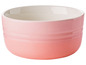 Un bol Le Creuset rose avec l'intérieur blanc.