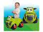 Un enfant joue avec un tracteur Claas en plastique vert.