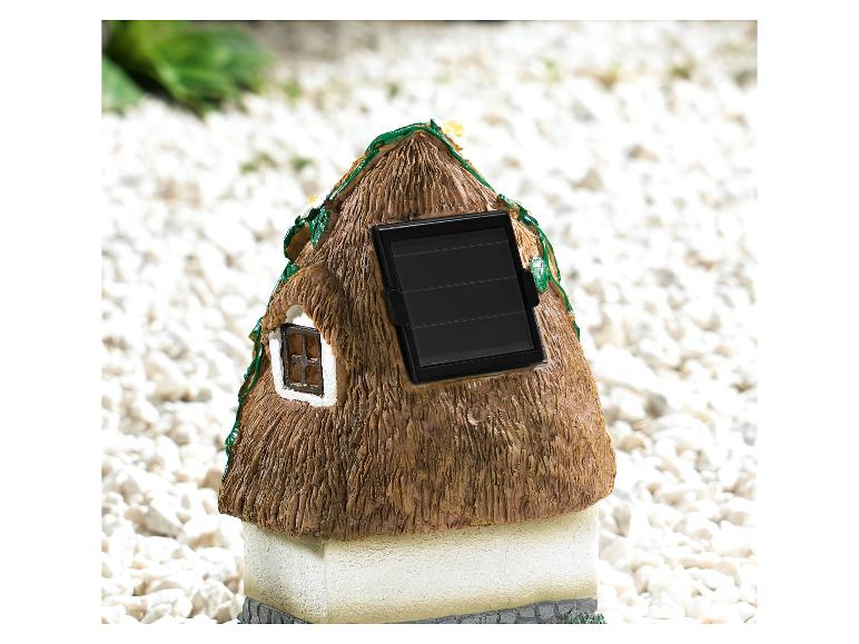 Une petite maison charmante avec un panneau solaire et une fenêtre.