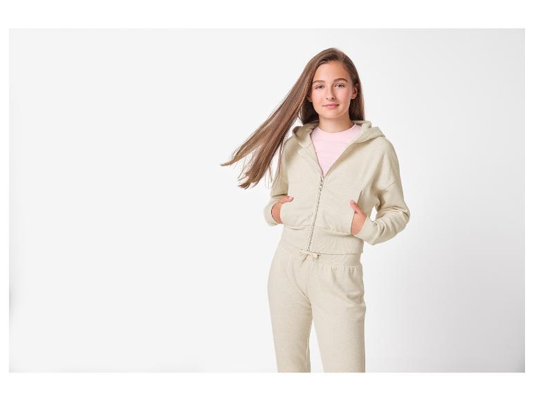 Adolescente en sweat à capuche zippé beige et pantalon de jogging assorti.