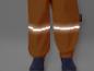 Pantalon de pluie orange avec des bandes réfléchissantes et du matériau 3M Scotchlite.