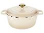 Cocotte en fonte émaillée crème avec couvercle et bouton doré.