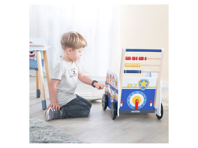 Un enfant joue avec une voiture en bois Paw Patrol avec un abaque.