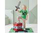 Garçon en t-shirt vert tenant une épée pixelisée, debout sur une boîte de rangement TNT.