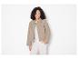 Une femme portant une veste beige et un pantalon blanc.