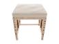 Banc d'extérieur avec coussin crème et base en osier.