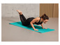 Une femme faisant des pompes sur un tapis de yoga turquoise de Decathlon.