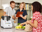 Une femme et un homme dans la cuisine, avec un Monsieur Cuisine Smart et des légumes frais.