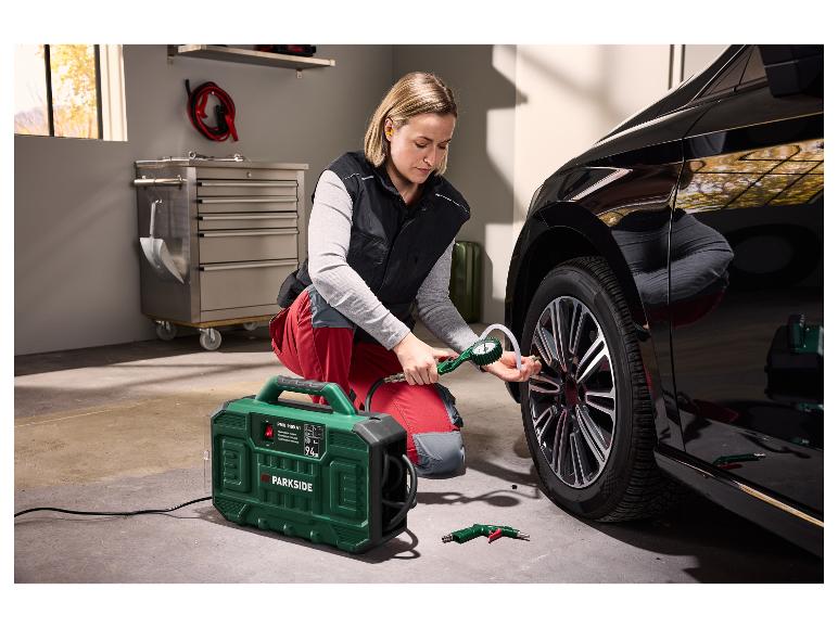 Femme gonflant le pneu d'une voiture noire avec un compresseur portable Parkside.