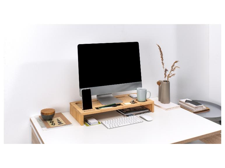 Un ordinateur, un clavier et une souris sur un organiseur de bureau en bambou.