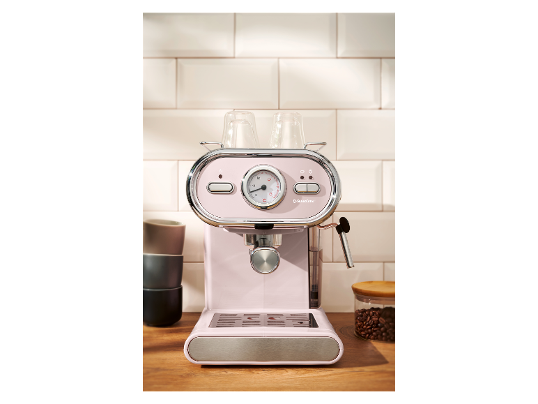 Machine à expresso rose pâle SilverCrest sur un comptoir en bois.