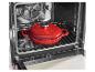 Cocotte en fonte rouge dans un four ouvert sur une grille
