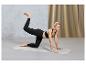 Femme en leggings noirs et soutien-gorge de sport faisant un exercice sur un tapis de yoga.