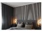 Chambre à coucher avec lit gris, tables de chevet et panneaux muraux en bois.