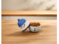 Boîte à biscuits en forme de bonhomme de neige remplie de biscuits sur une table en bois.