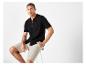 Un homme modèle porte un polo noir et un short beige.