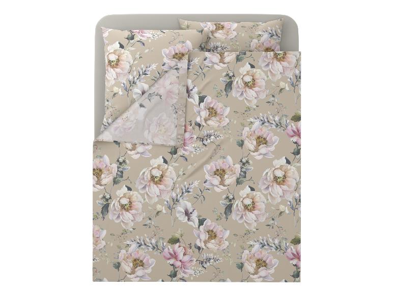 Parure de lit à motifs floraux beige et rose sur un lit.