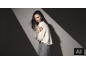 Femme portant un pull blanc et un pantalon gris.