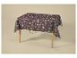 Nappe à motif automnal de feuilles et de champignons sur une table en bois.