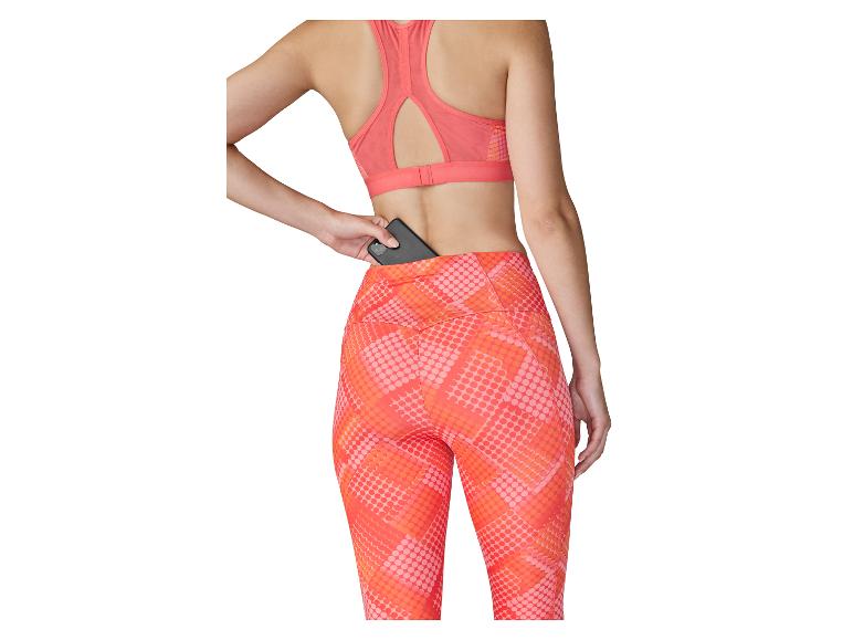 Femme en brassière de sport et legging avec une poche arrière, où elle range un téléphone.