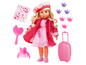 Une poupée avec des accessoires roses, y compris une valise, un miroir et des pinces à cheveux.