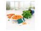 Bol de carottes râpées, carottes, basilic et un coupe-légumes.