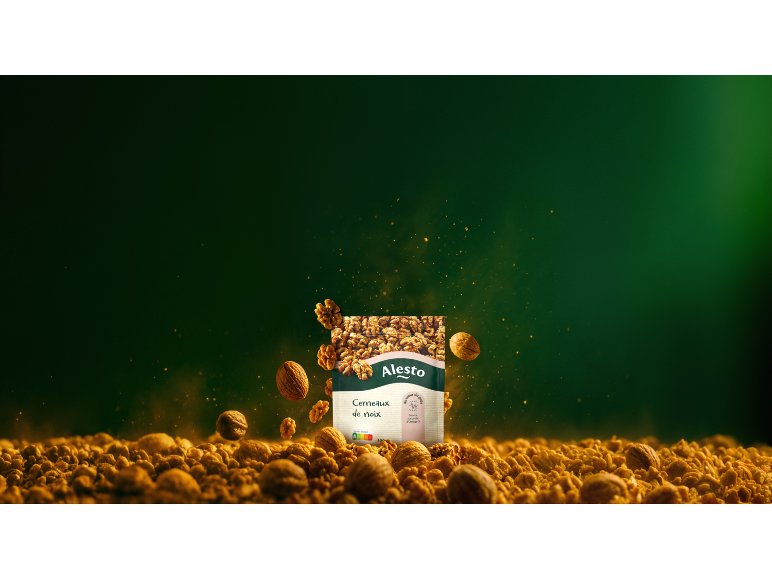 Sachet de noix avec des noix entières et des morceaux sur fond vert foncé.