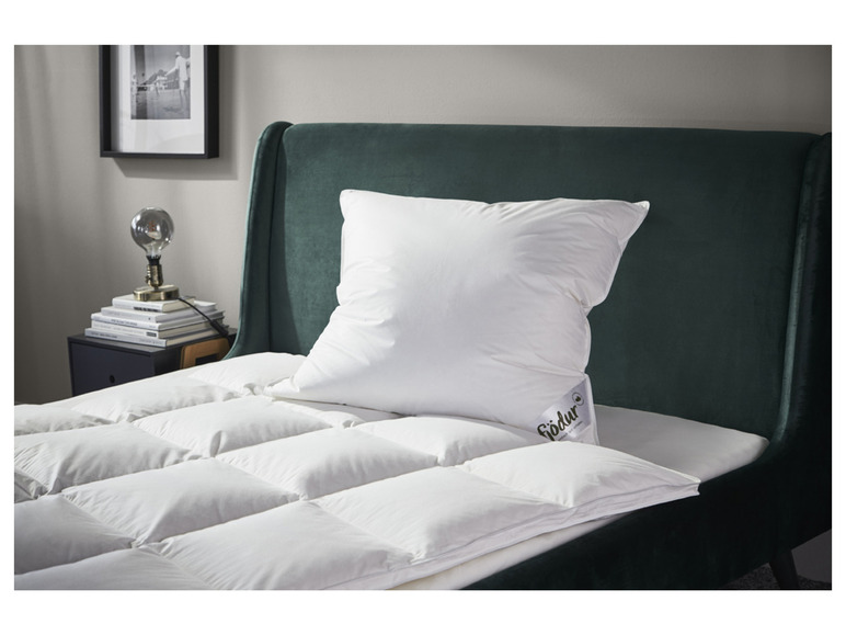 Une couette blanche et un oreiller de la marque Födür sur un lit vert foncé.