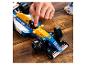 La main d'une personne ajustant un modèle de voiture de course Lego Williams de Formule 1 bleu et jaune.