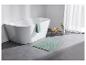 Baignoire, tapis de bain vert et accessoires de salle de bain.