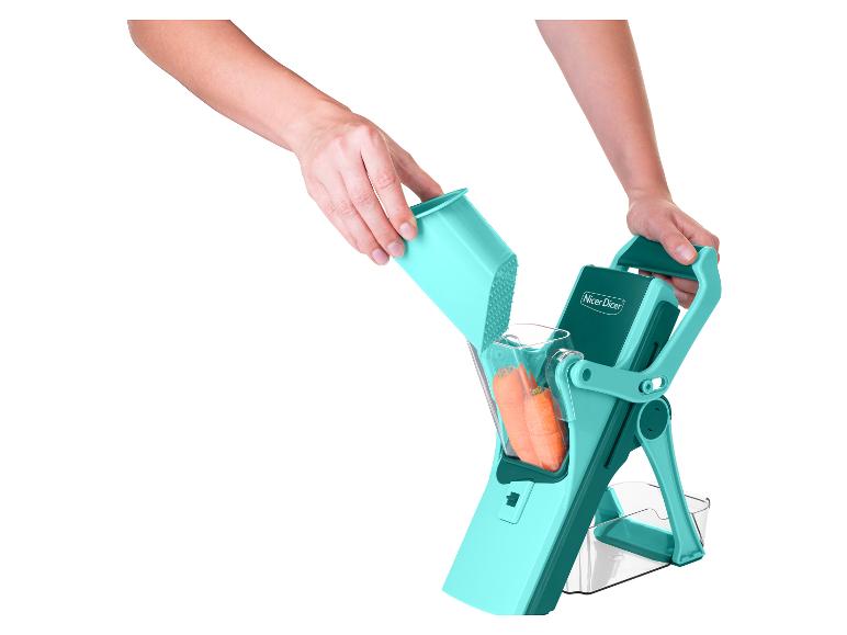 Nicer Dicer coupe-légumes turquoise avec carottes, tenu par des mains