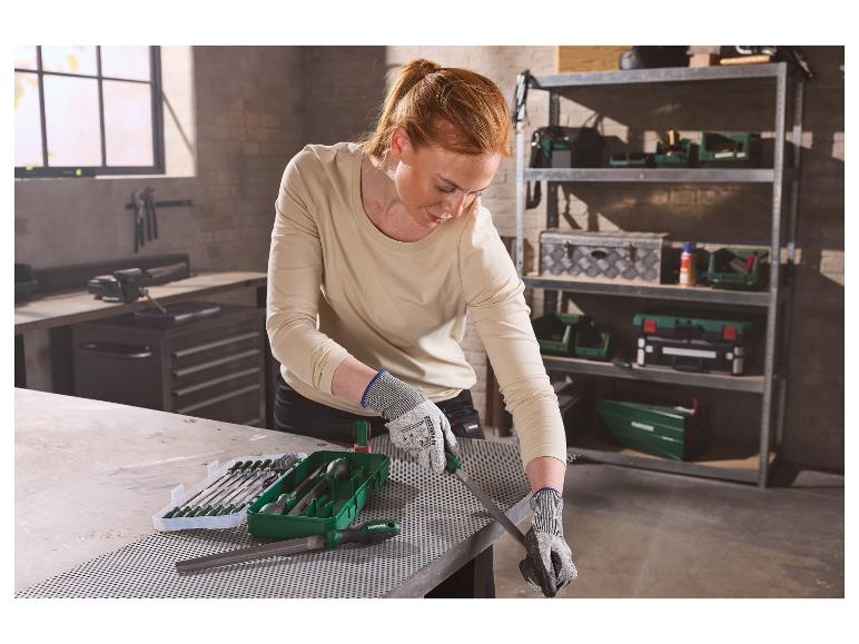 Femme lime du métal avec le set de limes d'atelier PARKSIDE® dans un atelier.