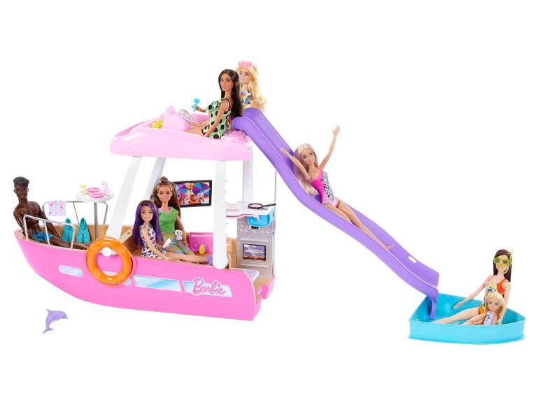 Poupées Barbie sur un yacht rose avec toboggan et piscine.